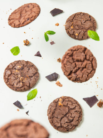 levitation chocolate homemade cookies with leaves mint on yellow background. Top view