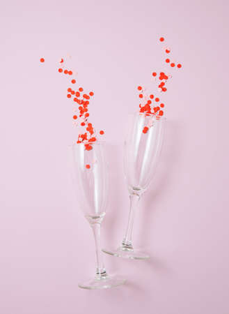 Flat lay of celebration. Two glasses with confetti  on a pastel pink  background. Concept of Valentine's Day, Mother's Day, wedding day. Top viewの写真素材