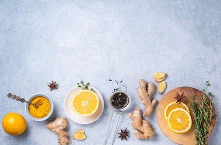 Immune boosting remedy. Flat lay  with ingredients for anti-virus drink from turmeric, thyme, lemon and  star anise on blue background. Top view, copy spaceの写真素材