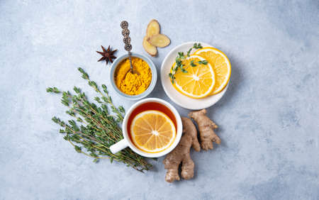 Creative flat lay with ingredients to boost immunity. Hot seasonal tea against viruses. Ingredients: ginger, thyme,  turmeric, anise and lemon. alternative medicine. Top view and copy spaceの写真素材