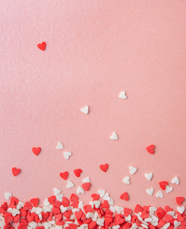 confetti in the form of red and pink hearts are scattered on a pink shiny background. Concept of Valentine's day, mother's day, wedding day. Top view and copy spaceの写真素材
