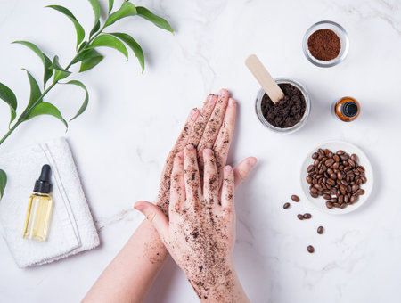 Spa concept. A young woman does a hand massage with a homemade coffee scrub from recycle capsule with olive oil on marble background. Top viewの写真素材