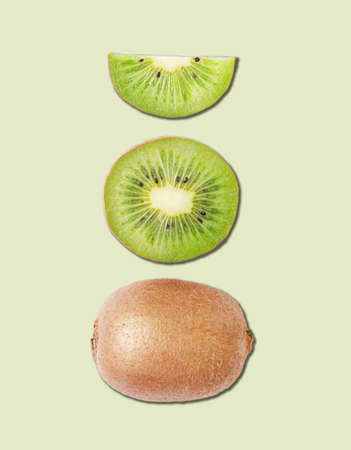Concept layout made from fresh sliced kiwi  and kiwi fruit on green background. Top view and macro.の写真素材