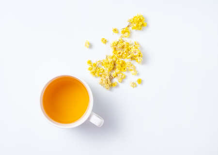 Fresh herbal tea with yellow flowers on a white background. Top view and copy spaceの写真素材