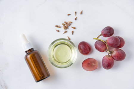 Flat lay is made of natural grape seed oil on white marble background. Natural cosmetics, healthy life style. Top view and copy spaceの写真素材