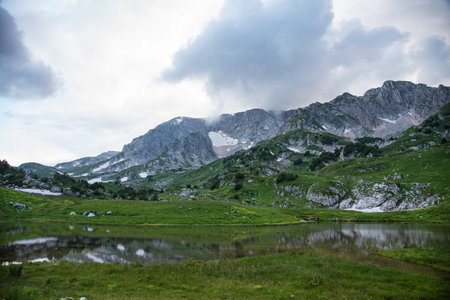 beautiful panoramic view of the mountain lake with tourist tents  a cloudy summer day. Adygea,...