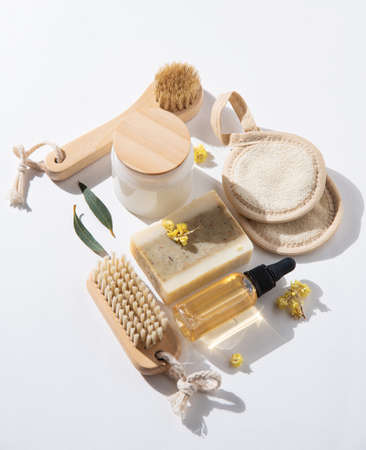 Eco-friendly and zero waste concept beauty spa  with natural cosmetic products: natural soap, sponges, oil  and massage brushes on white background with hard shadows.  Top view and copy space imageの写真素材