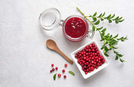 Concept flat lay with homemade lingonberry jam and forest cowberry in bowl on white background.  Top view and copy space imageの写真素材