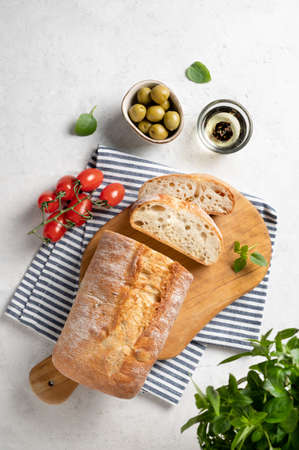 Fresh italian ciabatta bread cut  slices with tomato, basil and olive on white background. Top view  and copy space.の写真素材