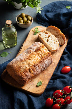 Italian ciabatta bread cut  slices with tomato, basil and olive on dark background.  Top view.の写真素材