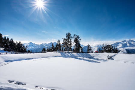Beautiful landscape of the Arkhyz ski resort with mountains, snow, forest and lake (pool) on a sunny winter day. Caucasus  Mountains, Russia.の写真素材