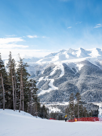 Beautiful landscape of the Arkhyz ski resort with mountains, snow, forest, skiers and snowboarders  on a sunny winter day. Caucasus  Mountains, Russia.の写真素材