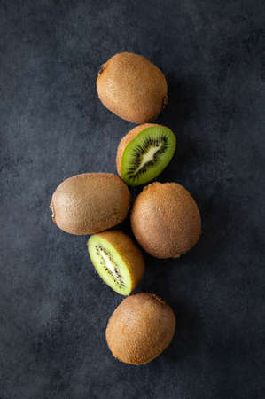 Fresh and sweet kiwi fruits on a dark background. The concept of healthy and dietary food. Top view, copy space.の写真素材