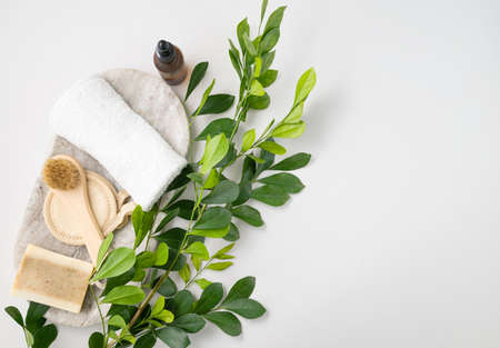 Flat lay of facial and body care cosmetics with soap, brush, sponge, creme and towel  on white  background with brunch. Zero waste concept. Top view and copy space.の写真素材