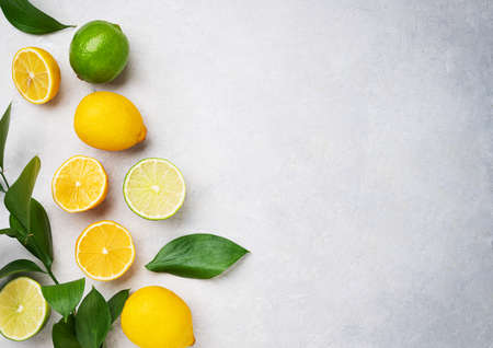 Fresh lemons and limes on a blue textured background. Citrus fruit concept for freshly squeezed lemonade. Top view and copy space.の写真素材