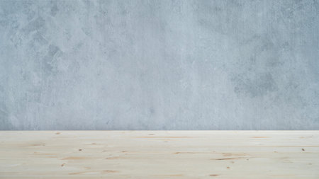 A light wooden table top with free space for installing a product or layout on a blue textured...
