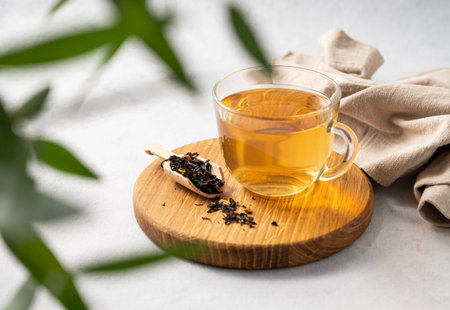 Fragrant herbal tea in a glass cup on a cutting board and white background with eucalyptus branches...