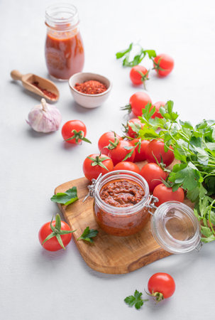 Salsa sauce is a traditional Mexican sauce with tomatoes and hot peppers on a light background with fresh herbs. Concept of a vegetarian food.の写真素材