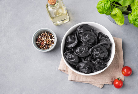Black dumplings with meat, herbs and spices on a gray background. Russian seberian tradition food. Top view and copy space.の写真素材
