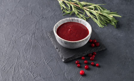 Handmade jam in a bowl with fresh berries and rosemary on a dark background. Concept homemade healthy food. Free space forv text.の写真素材