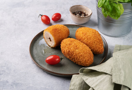 Chicken Kiev cutlets on a plate with fresh tomatoes, herbs and spices. Free space for text.の写真素材