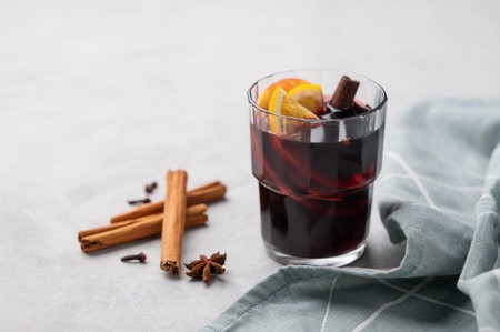 Mulled wine with orange, apple  and cinnamon in glass on a light background. The concept of a...