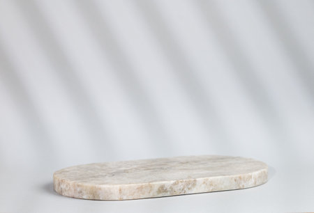 Abstract empty marble board with shadows on a gray background. Layout concept for promotional product presentation, sale or cosmetics display. Front view and copy space.の写真素材