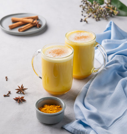 Turmeric golden milk latte with spices and honey. Detox, immunity boosting, anti-inflammatory, healthy, cozy drink in a glass cup on a light background.の写真素材