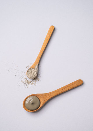 Blue clay in a spoon on a light background. Concept for preparing homemade skincare organic cosmetics and spa treatment. Top view and copy space.の写真素材