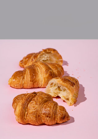 Fresh croissants on pink and gray  background. Creative layout and concept of healthy food and...