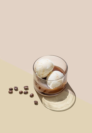 Affogato coffee with vanilla ice cream scoops  and espresso in a glass on a light background with...