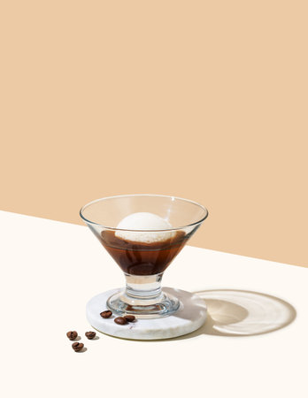 Affogato coffee with a scoop of vanilla ice cream and espresso in a glass on a white beige...