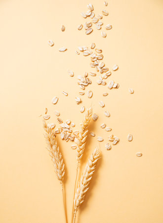 Oat flakes with wheat scattered on a yellow background. Healthy eating and wholesome diet breakfast concept. Advertising layout or banner for nutrition food.  Top view and copy space.の写真素材