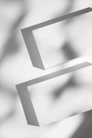 Minimalist blank rectangular boxes casting shadows on white background. Concept abstract geometric...