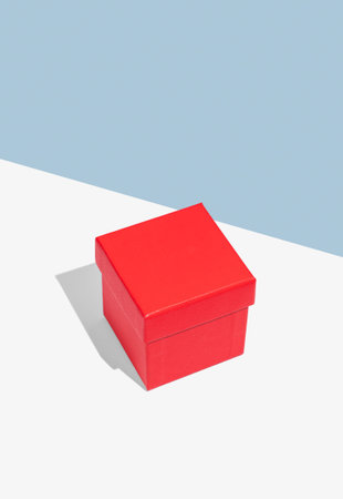 Red box on a white and blue background with soft shadows. Concept of a gift for a holiday, a...