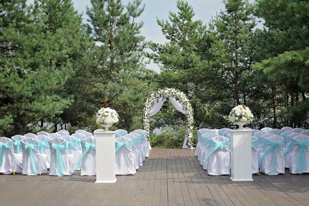 Beautiful wedding ceremony decorated with arch, flowers and chairs.の写真素材