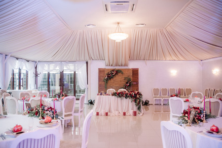 Beautifully decorated wedding hall in white and red coloursの写真素材