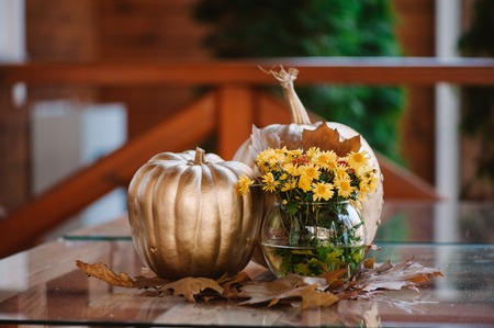Golden pumpkin decoration with the yellow flowersの写真素材