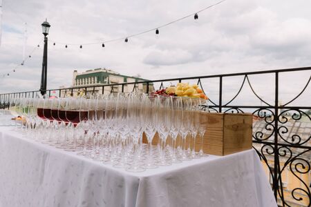 Wineglasses for the wedding catering on the table outdoorsの写真素材