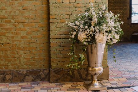 Floral vase near the brick wall as a wedding decorationの写真素材