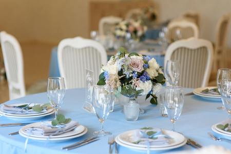 Lunch table for guests at a wedding. Fresh flowers in a vase on a tableの写真素材