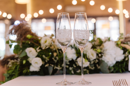 Glasses of the groom and bride on a wedding tableの写真素材
