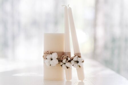 Stylish wedding accessories are white in rustic style. Set of candles for family hearthの写真素材