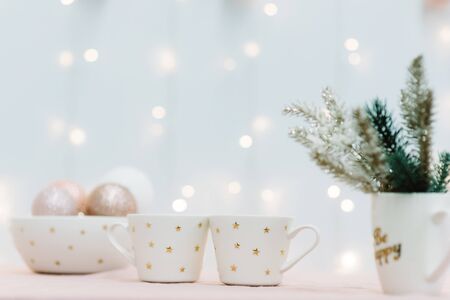 Two cups for christmas cocoa with marshmallows, golden stars, new year tree, scandinavian kitchen, festive backgroundの写真素材