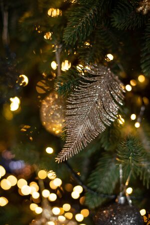 A variety of beautiful Christmas tree toys. Branch artificial spruce in the house. Graceful metal leafの写真素材