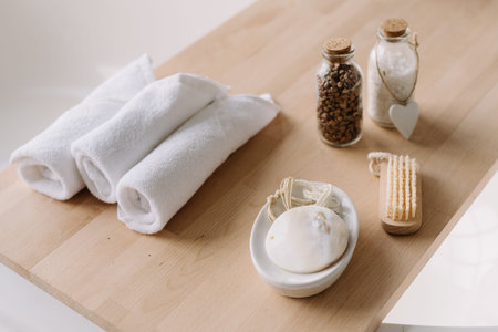 Small and clean white towels on a wooden board. Stylish bathroom details. Spa and relax concept