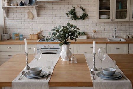Modern stylish white and light wood Scandinavian kitchen interior with kitchen accessories. Table servingの写真素材
