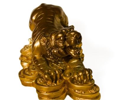 statuette of a tiger guarding gold coins isolated on white backgroundの写真素材