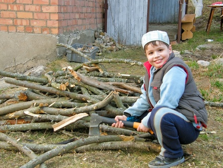 eight years old boy chopping wood in the countryの写真素材