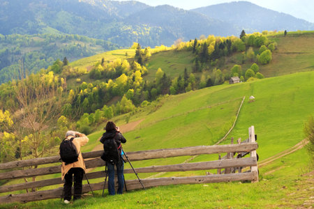 Photographers take pictures of spring rural landscape in the Carpathian mountains